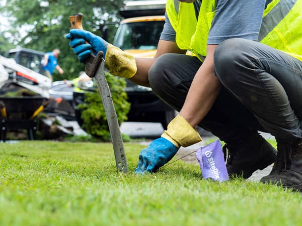 Man Cutting Sod With Large Garden Knife