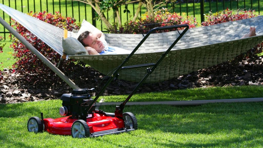 Man Napping In Hammock Beside Lawn Mower